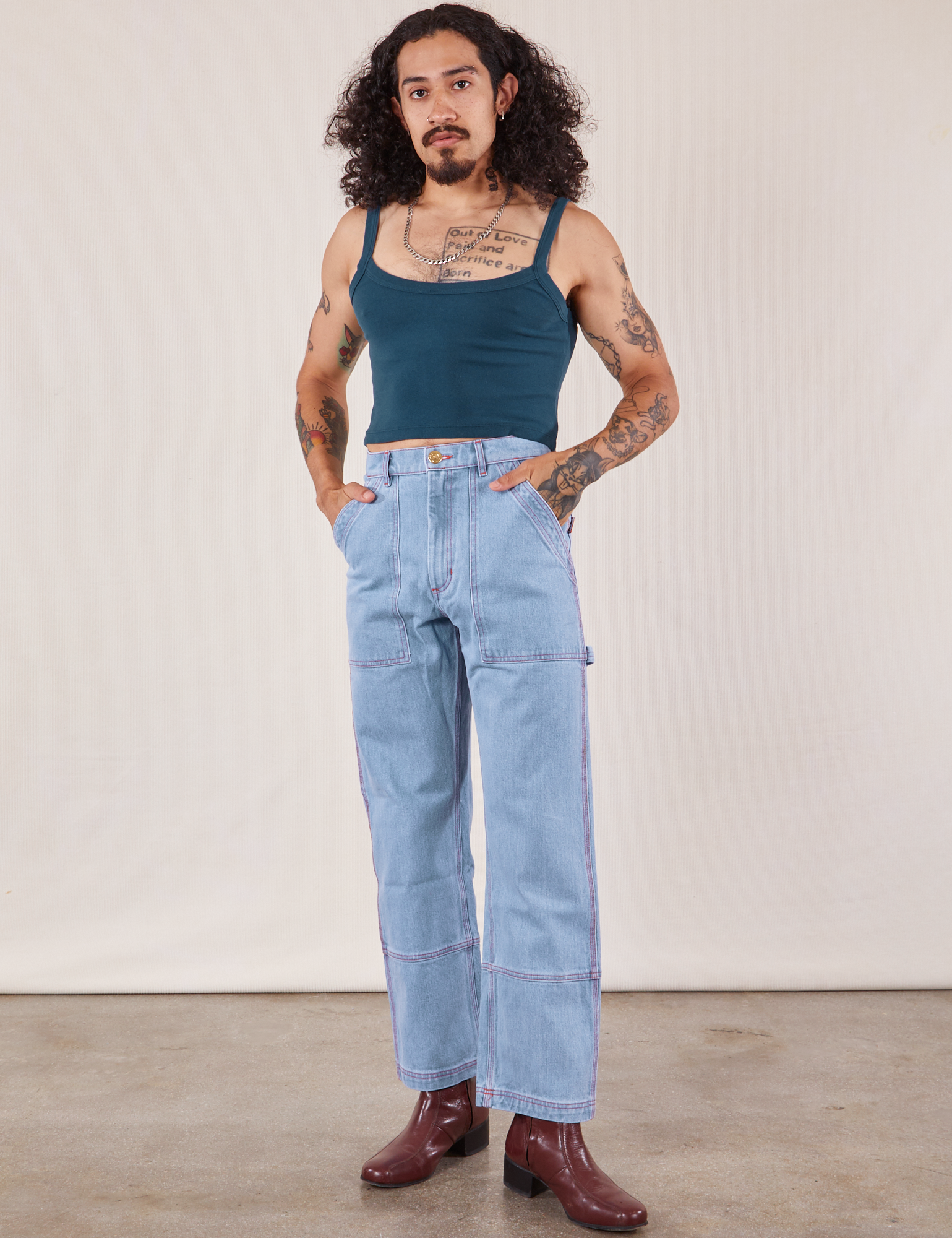 Jesse is wearing Cropped Cami in Lagoon and light wash Carpenter Jeans