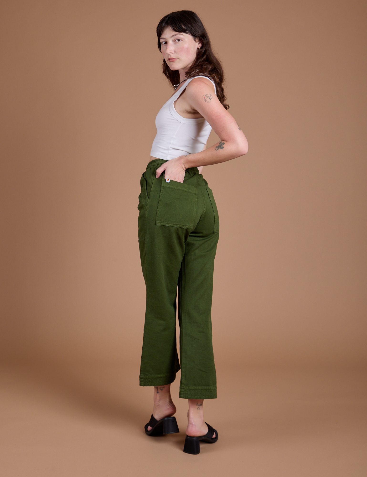 Angled back view of Organic Action Pants in Evergreen on Alex