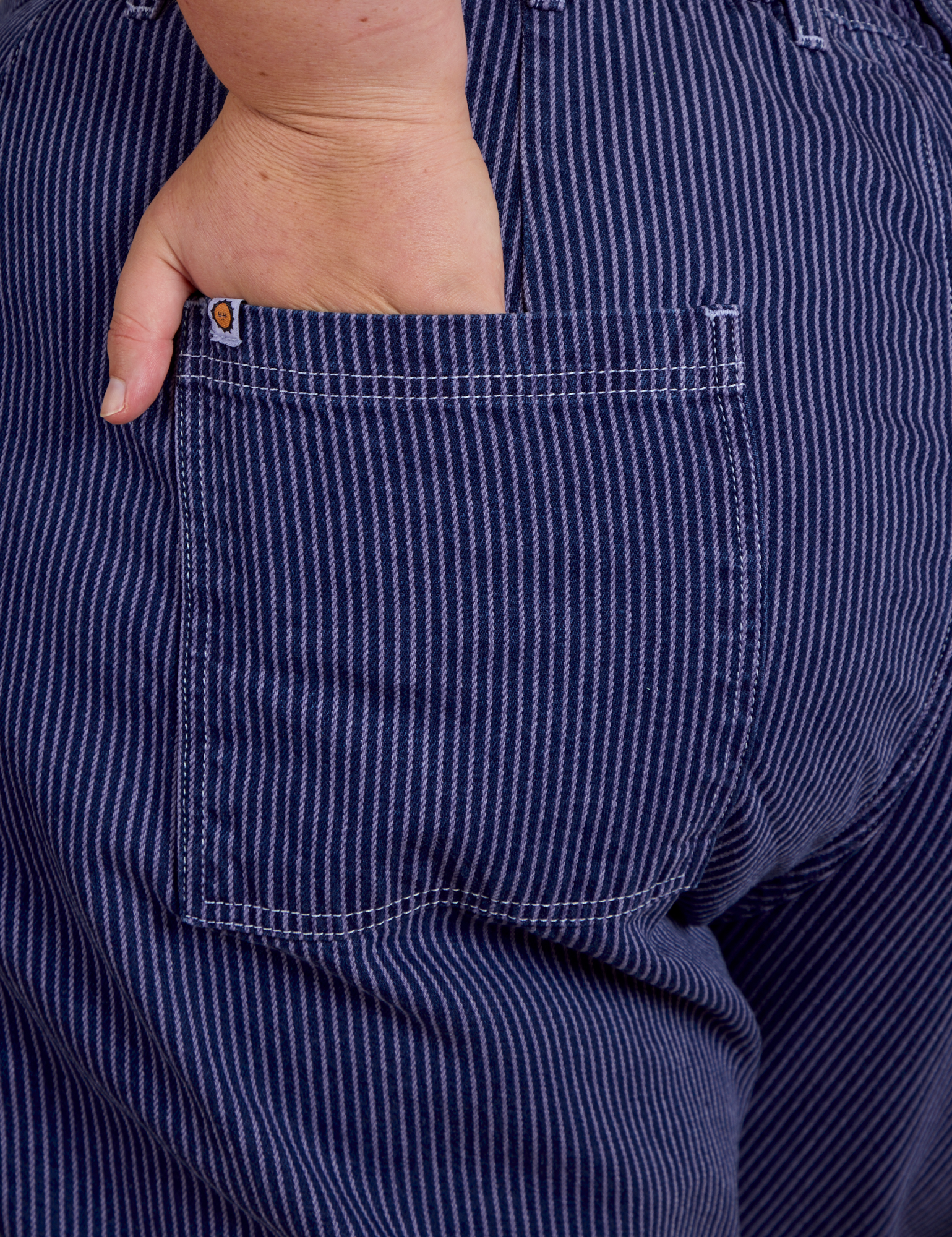 Close up of Juliet's hand in the back pocket of Railroad Denim Work Pants in Faded Grape Overdye