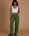 Kandia is 5’3” and wearing XS Railroad Denim Work Pants in Gross Green Overdye paired with vintage tee white Cropped Tank