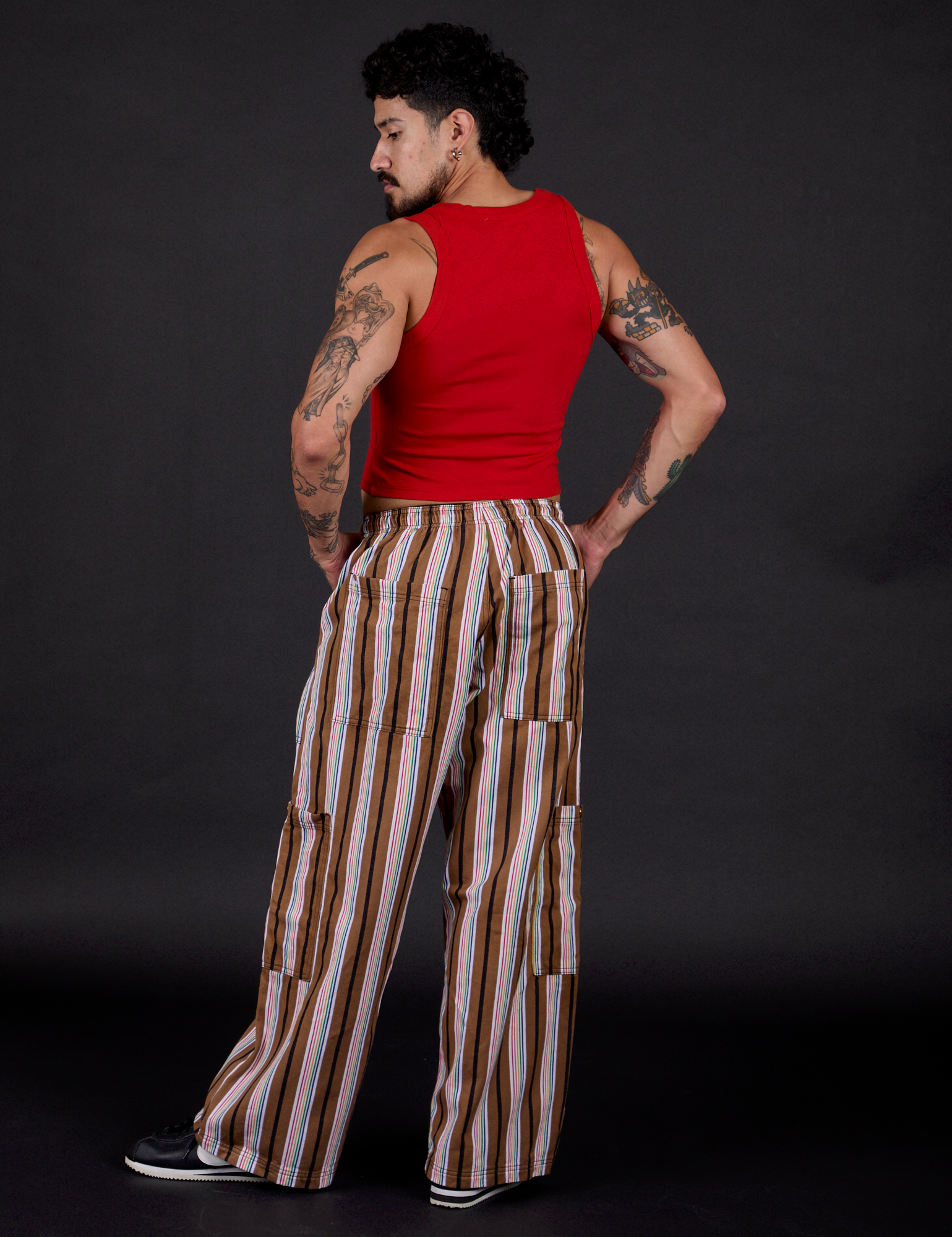 Angled back view of Striped Drop Pocket Pants in Retro Rainbow and mustang red Cropped Tank