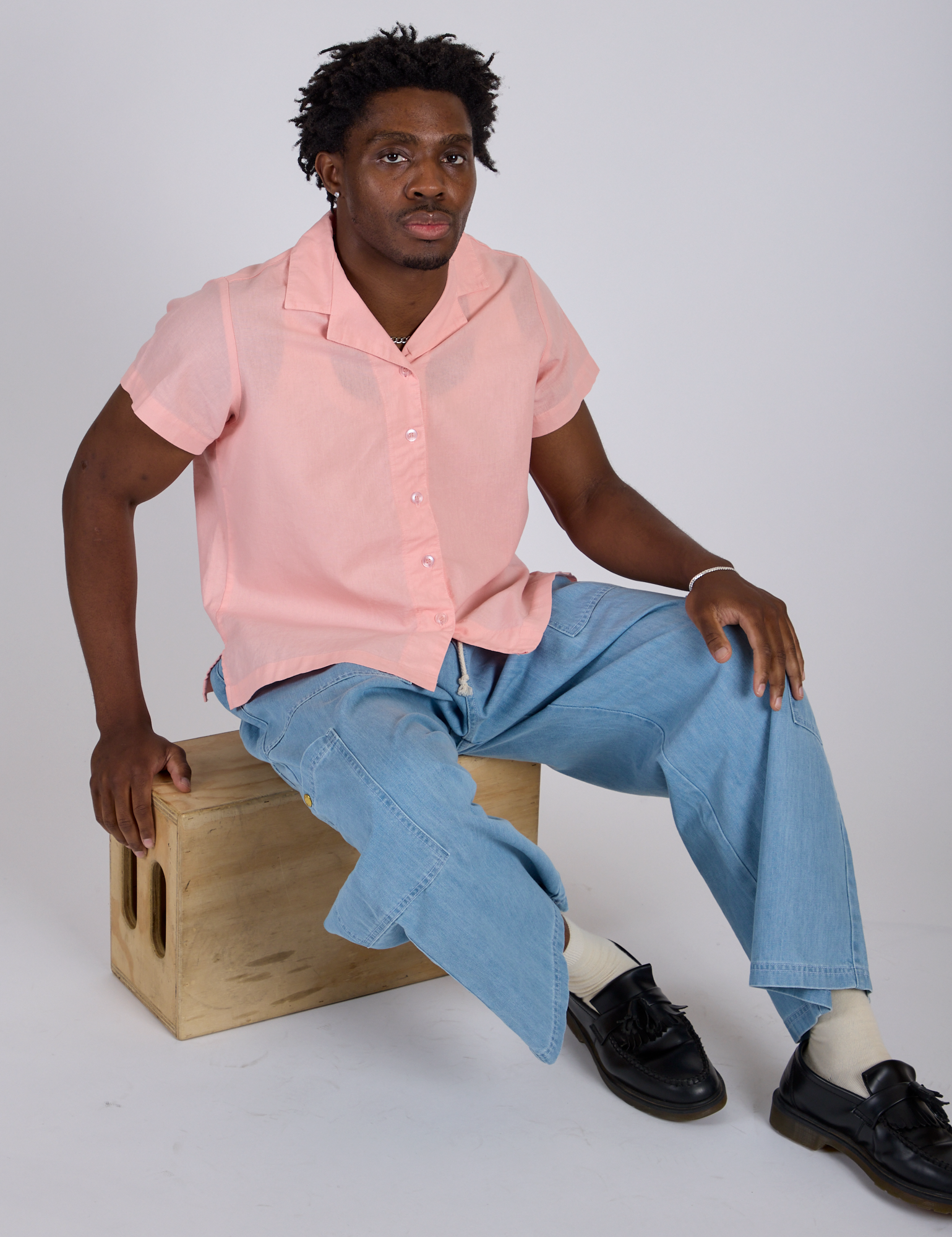 Isaac is wearing Pantry Button-Up in Baby Pink and light wash Denim Drop Pocket Pants
