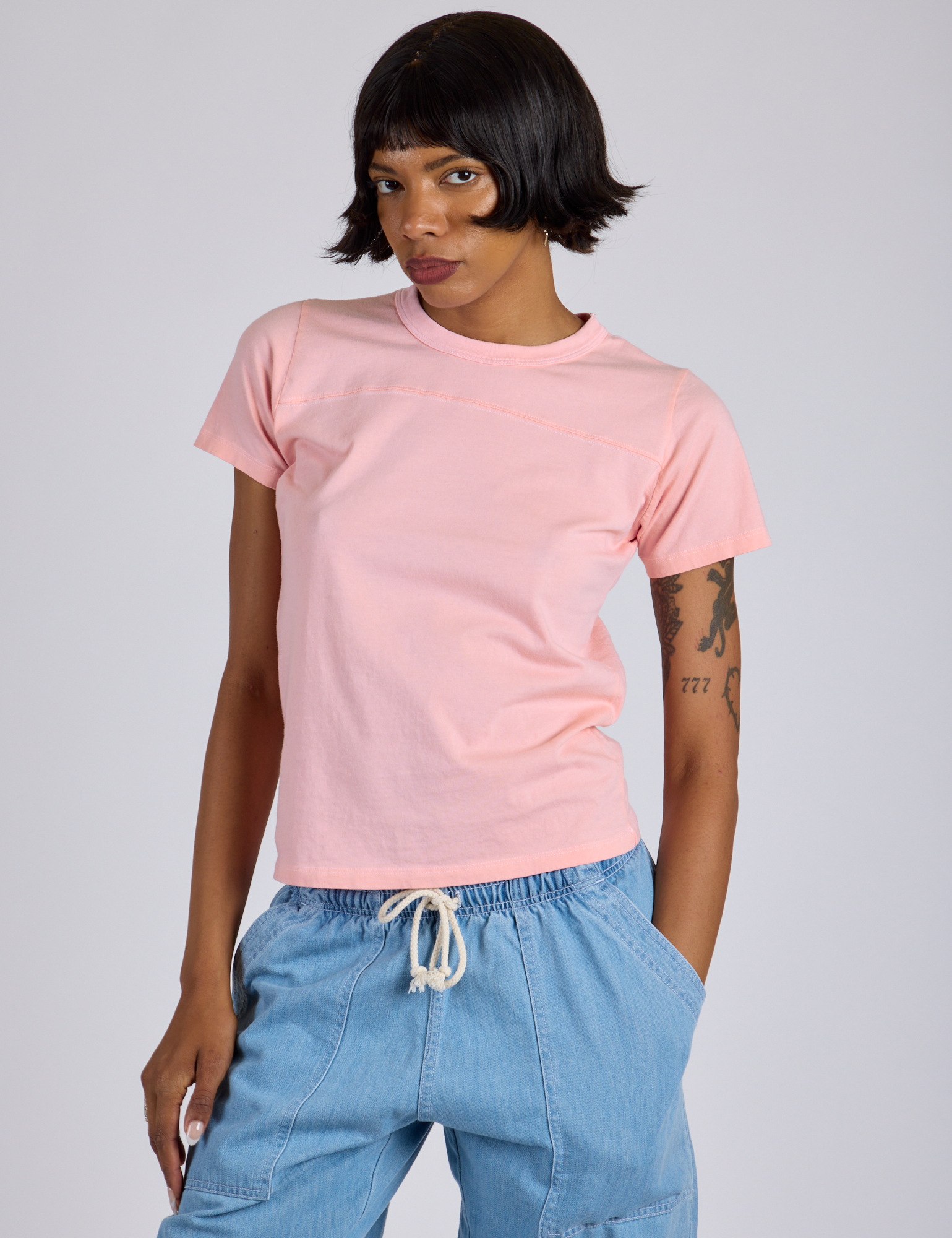 Kira is 5’10” and wearing P Jr. Varsity Tee in Baby Pink