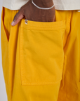 Close up of Isaac's hand in the back pocket of Drop Pocket Cargo Pants in Sunshine Yellow
