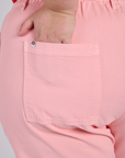 Close up of Juliet's hand in the back pocket of Work Pants in Baby Pink
