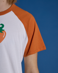 Close up of Produce Raglan Tee in Habanero sleeve on Grant