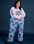 Sam is wearing Floral Long Sleeve Baby Tee in Pink and Floral Painted Work Pants in Blue