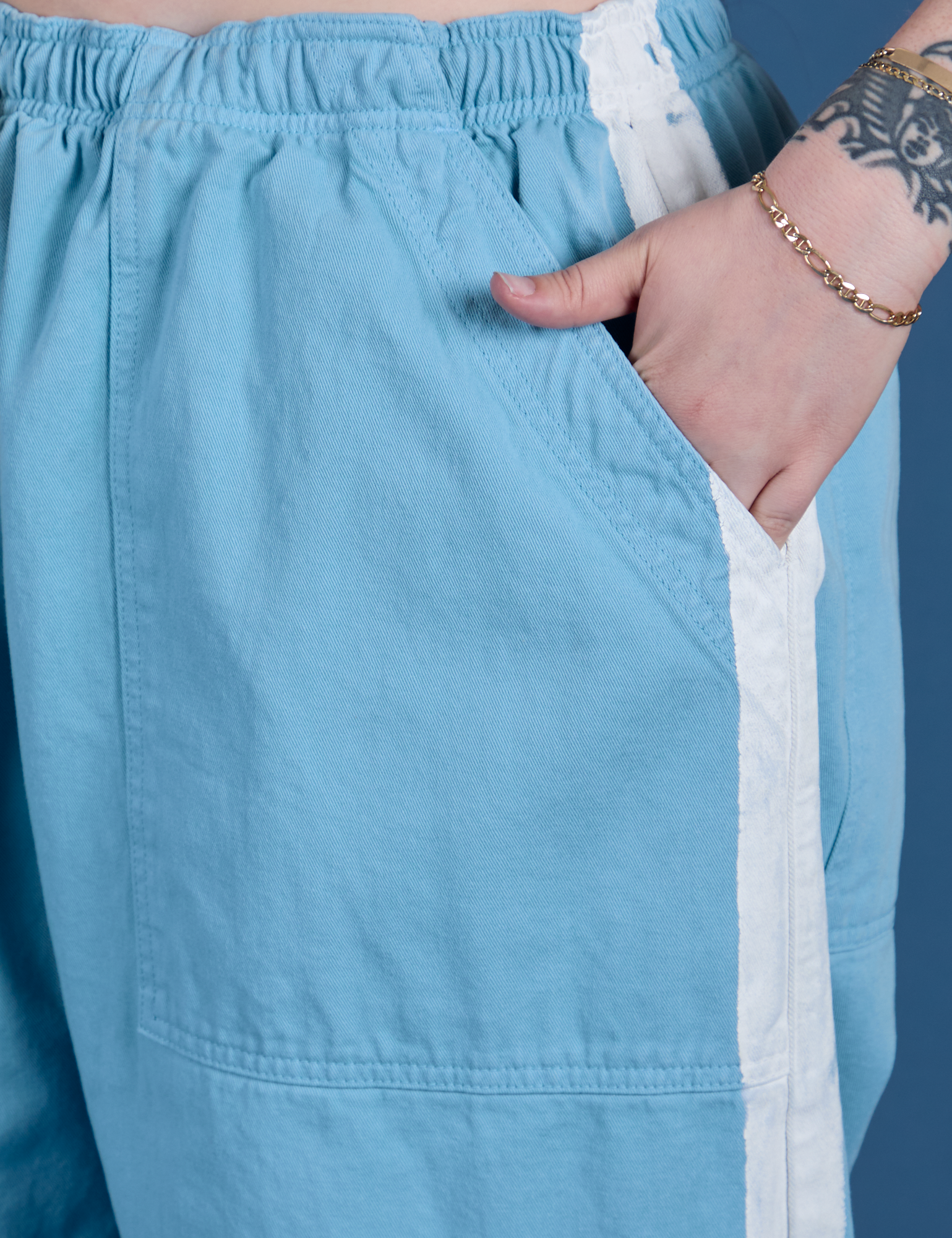Close up of Sydney's hand in the front pocket of Painted Drop Pocket Cargo Pants in Baby Blue