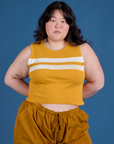Ashley is 5’7” and wearing L Painted Muscle Tee in Mustard Yellow