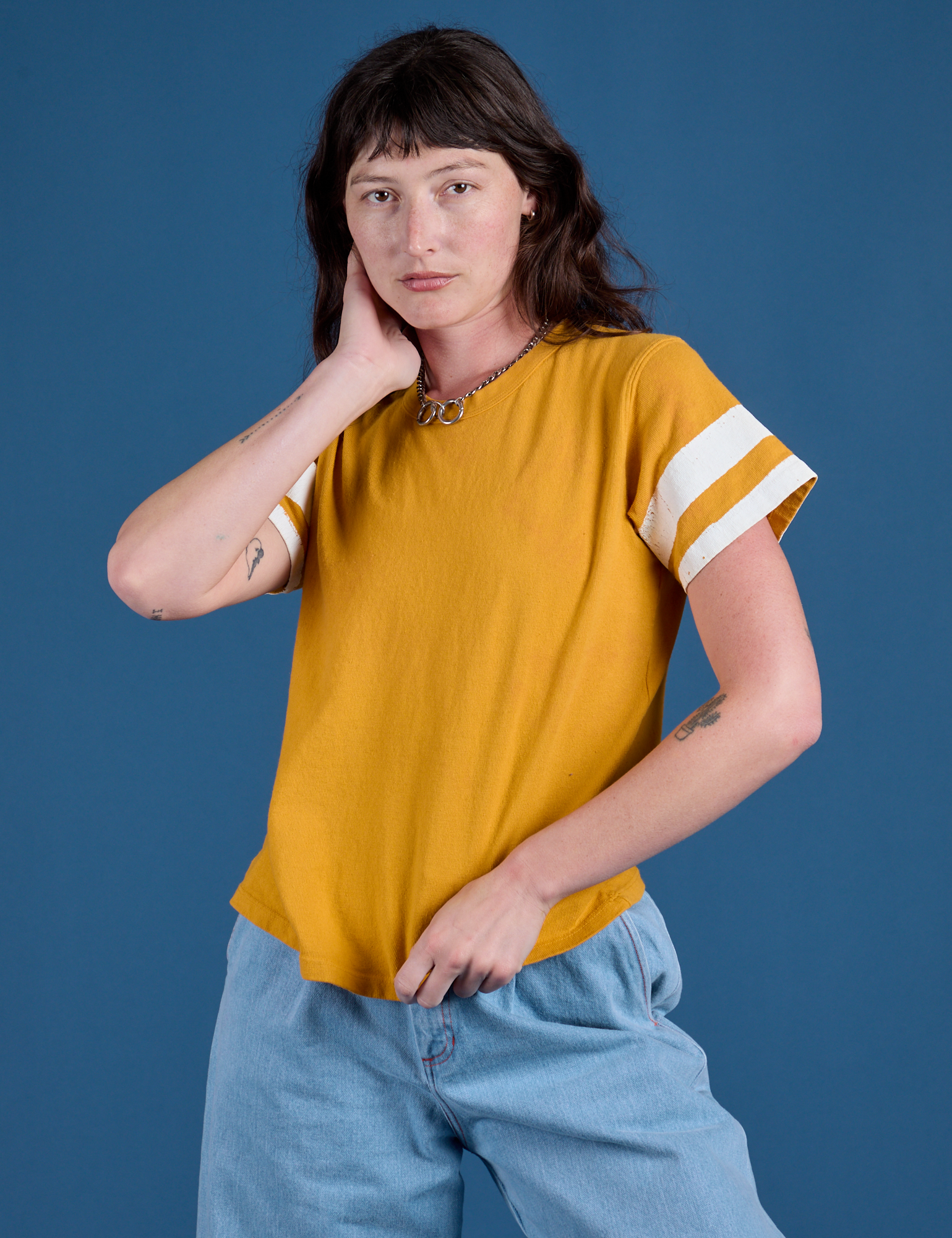 Alex is 5’8” and wearing P Painted Burly Tee in Mustard Yellow