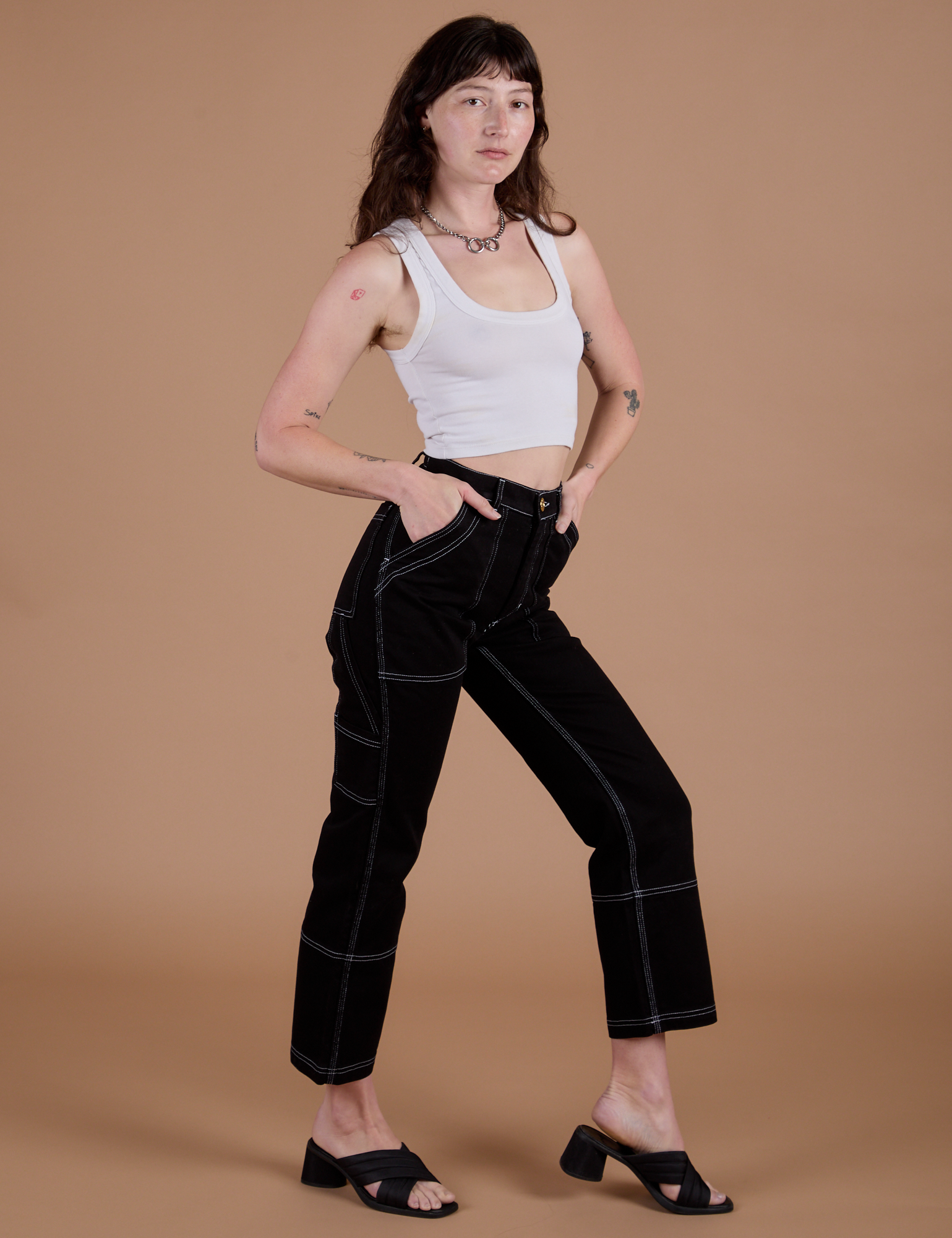 Angled front view of Carpenter Jeans in Black and Cropped Tank in Vintage Tee White on Alex