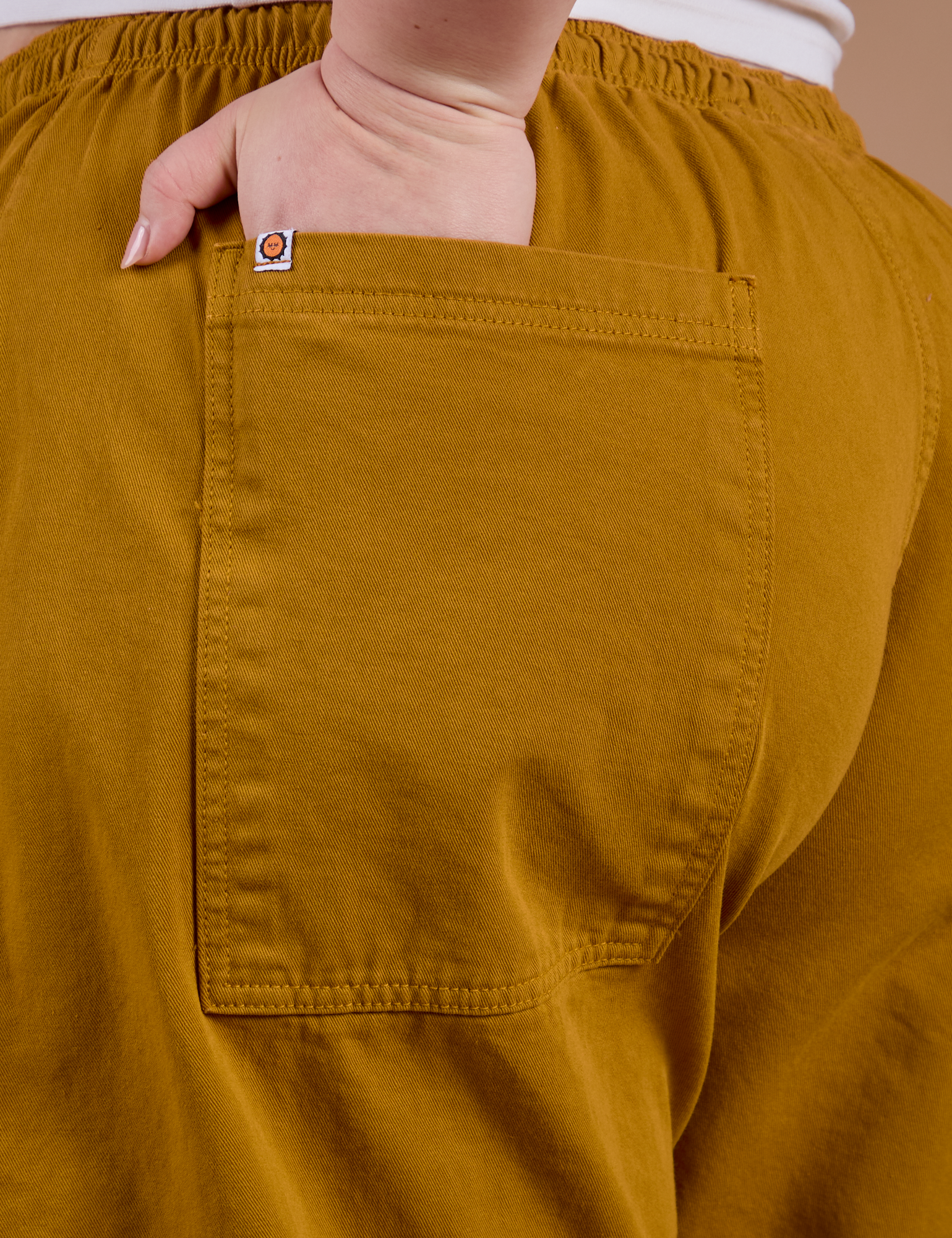 Close up of Ashley's hand in the back pocket of Drop Pocket Cargo Pants in Spicy Mustard 