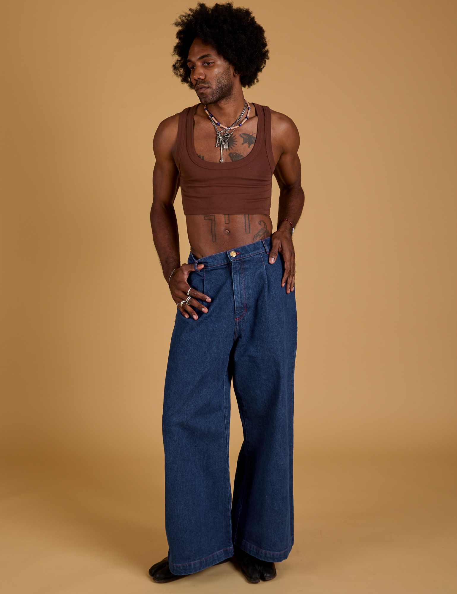 Jerrod is wearing Mini Tank in Fudgesicle Brown and dark wash Indigo Wide Leg Trousers