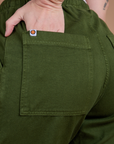 Close up of Alex's hand in the back pocket of Organic Action Pants in Evergreen