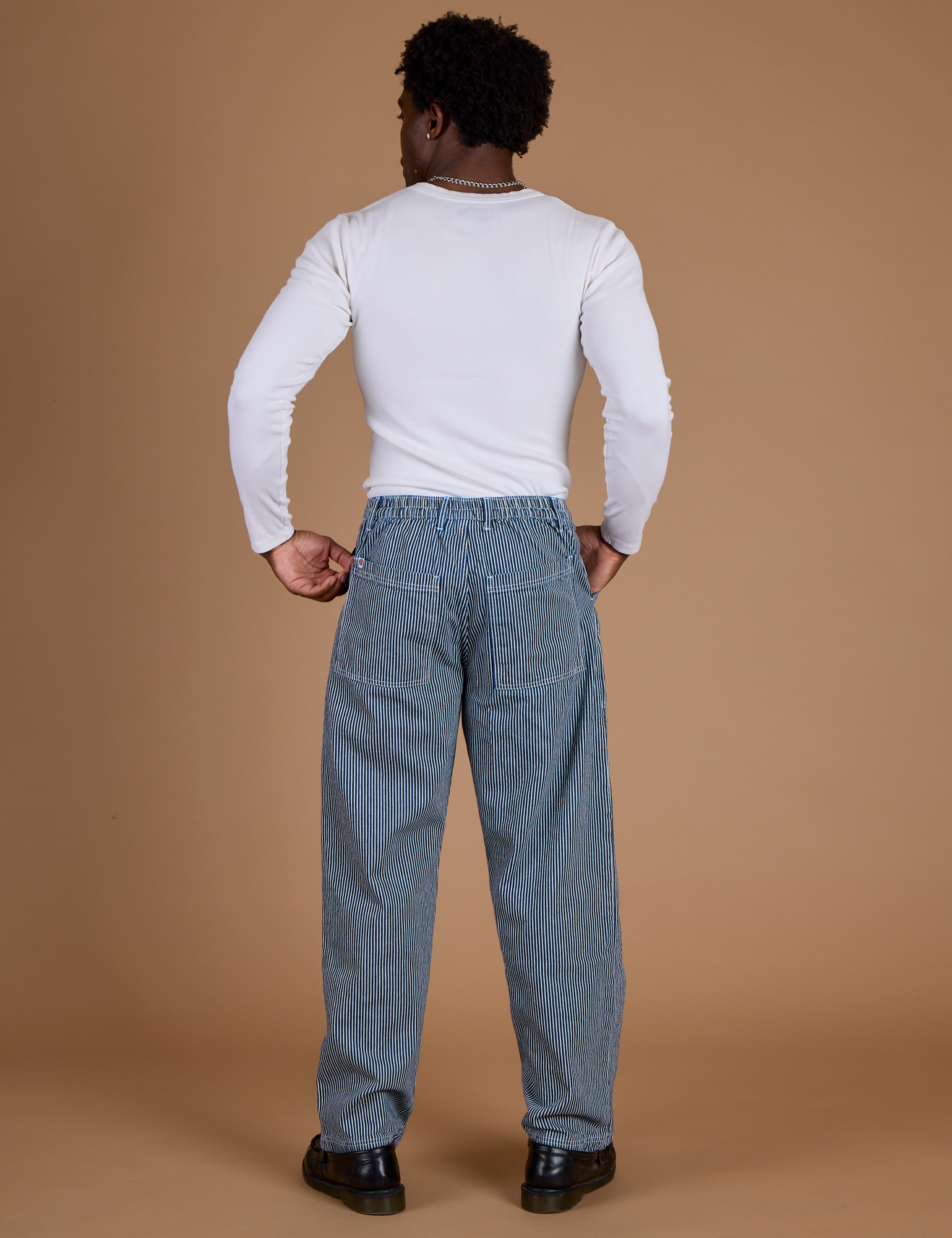 Back view of Railroad Denim Work Pants in Natural and vintage tee white long Sleeve Baby Tee