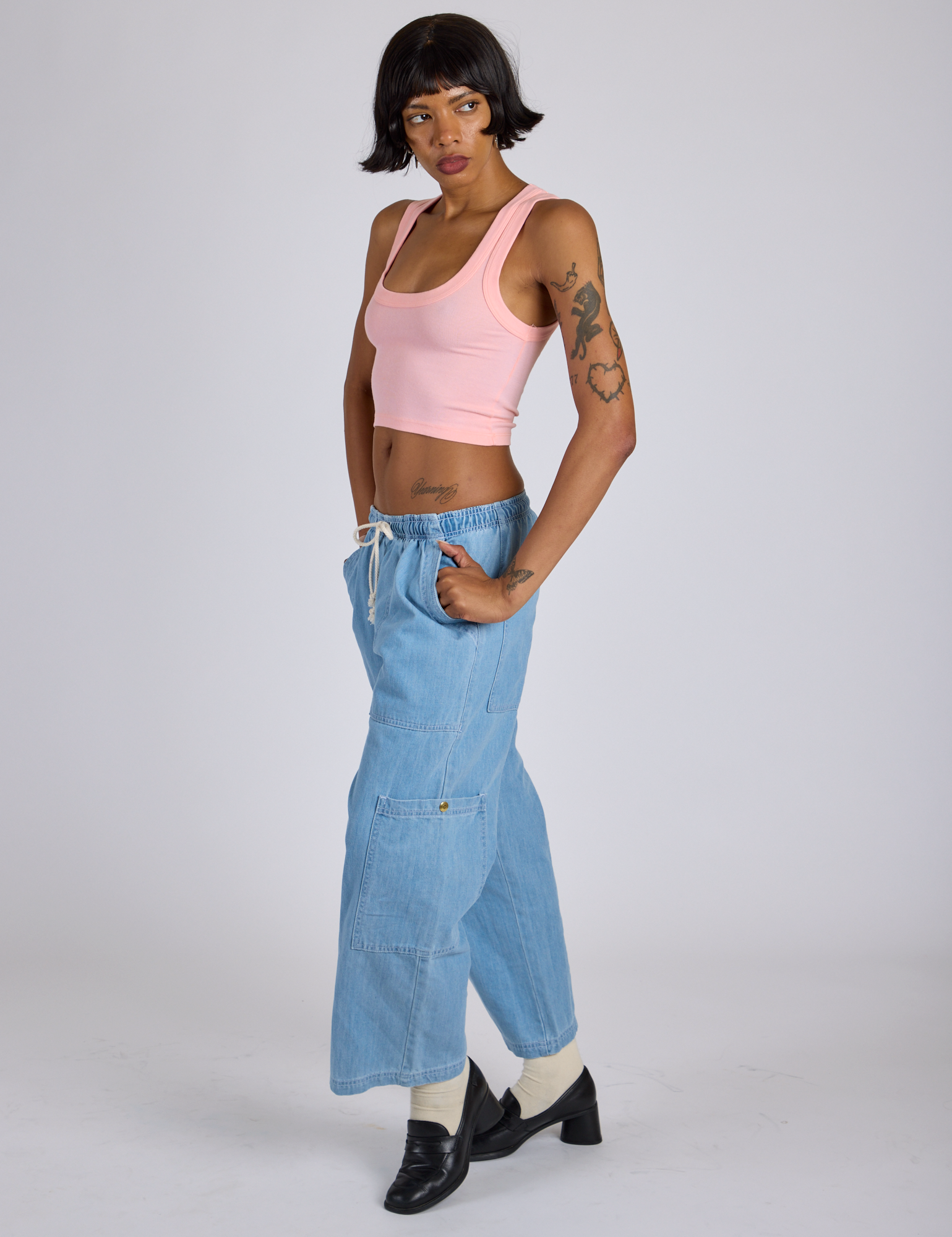 Angled front view of Cropped Tank Top in Baby Pink and light wash Denim Drop Pocket Pants