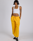 Kira is 5’10” and wearing XS Drop Pocket Cargo Pants in Sunshine Yellow paired with a Cropped Tank in Vintage Tee White
