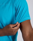 Close up of Isaac holding the sleeve of Jr. Varsity Tee in Hawaiian Blue