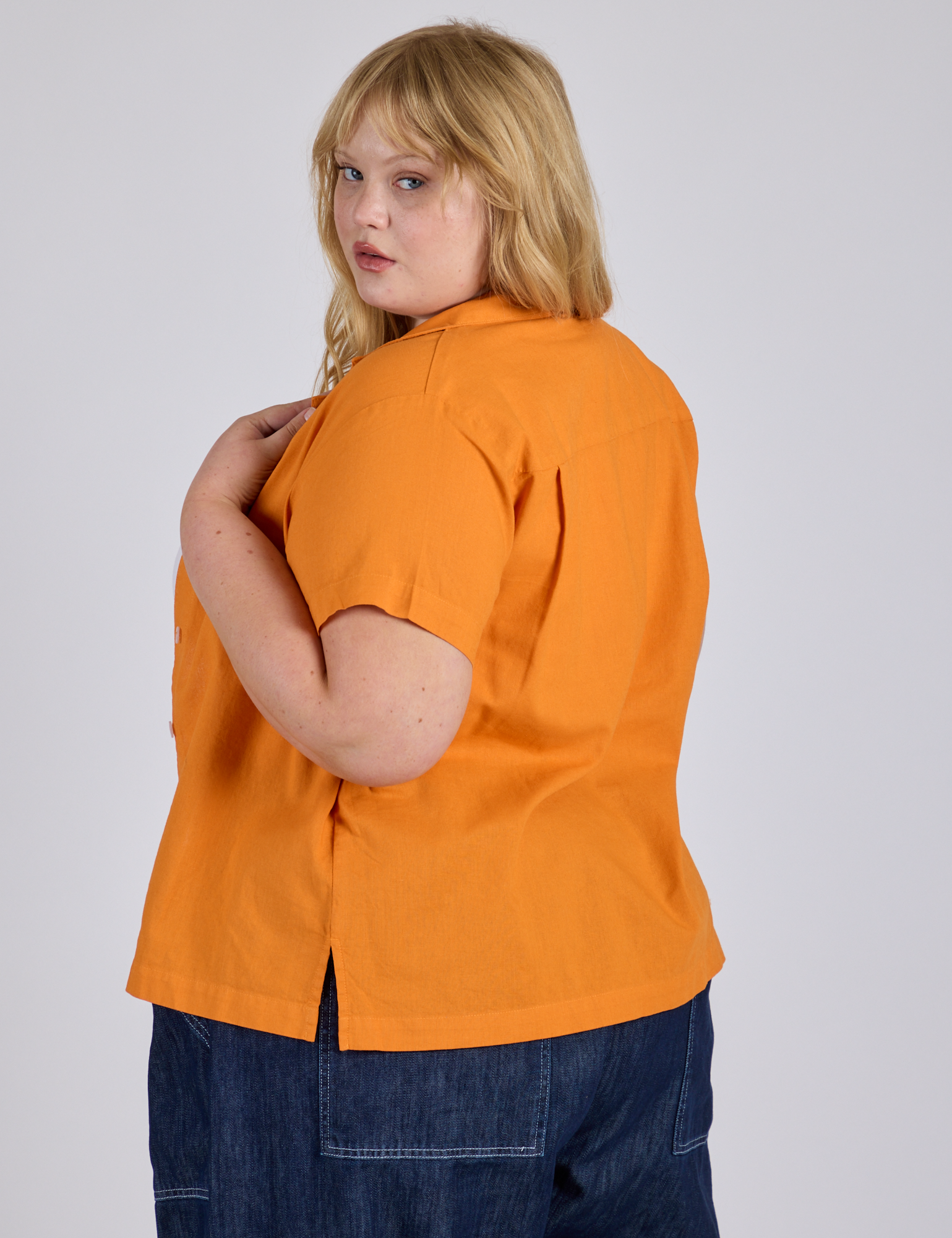 Angled back view of Pantry Button-Up in Creamsicle Orange on Juliet