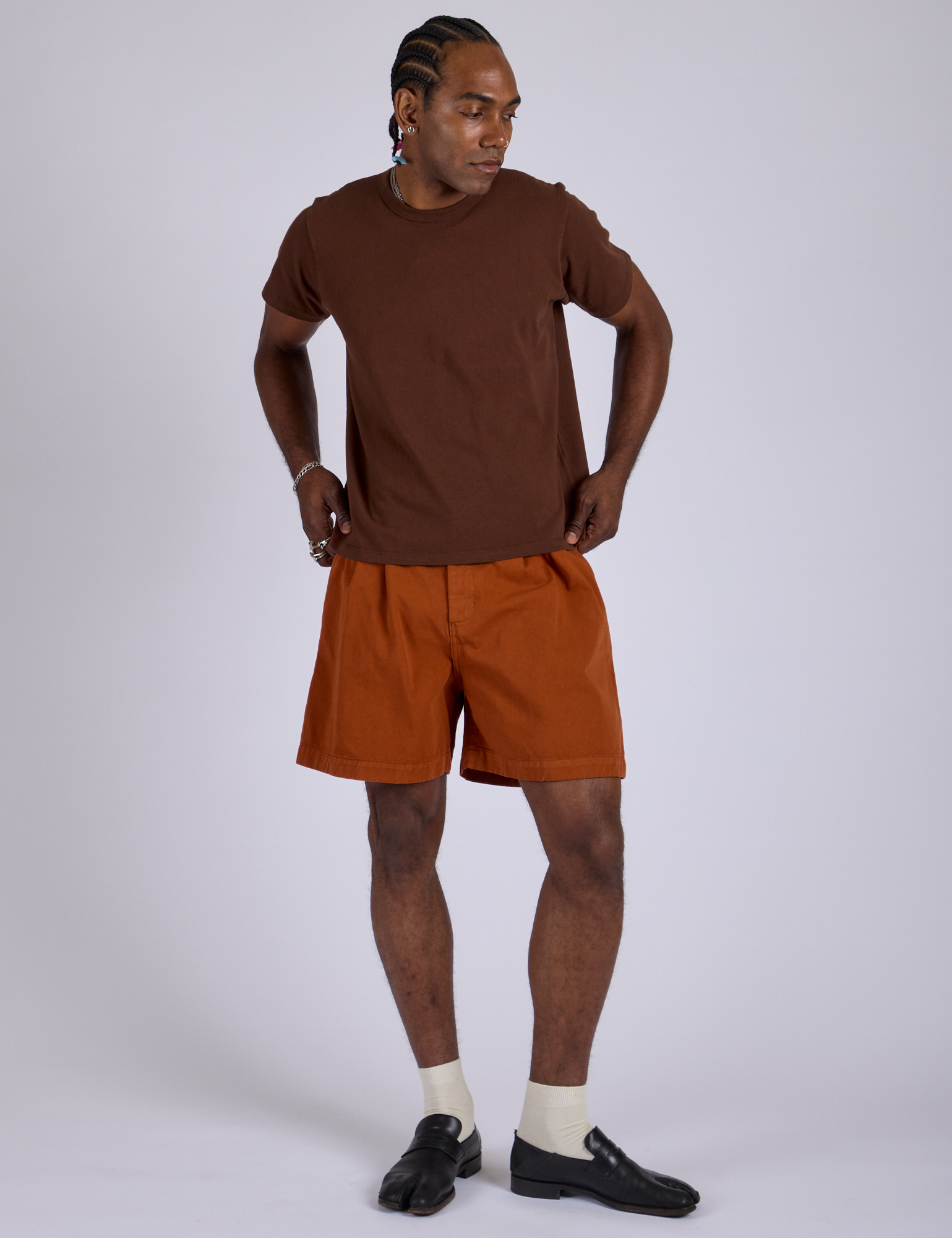 Jerrod is 6’3” and wearing M Pleated Trouser Shorts in Burnt Terracotta paired with fudgesicle brown Organic Vintage Tee