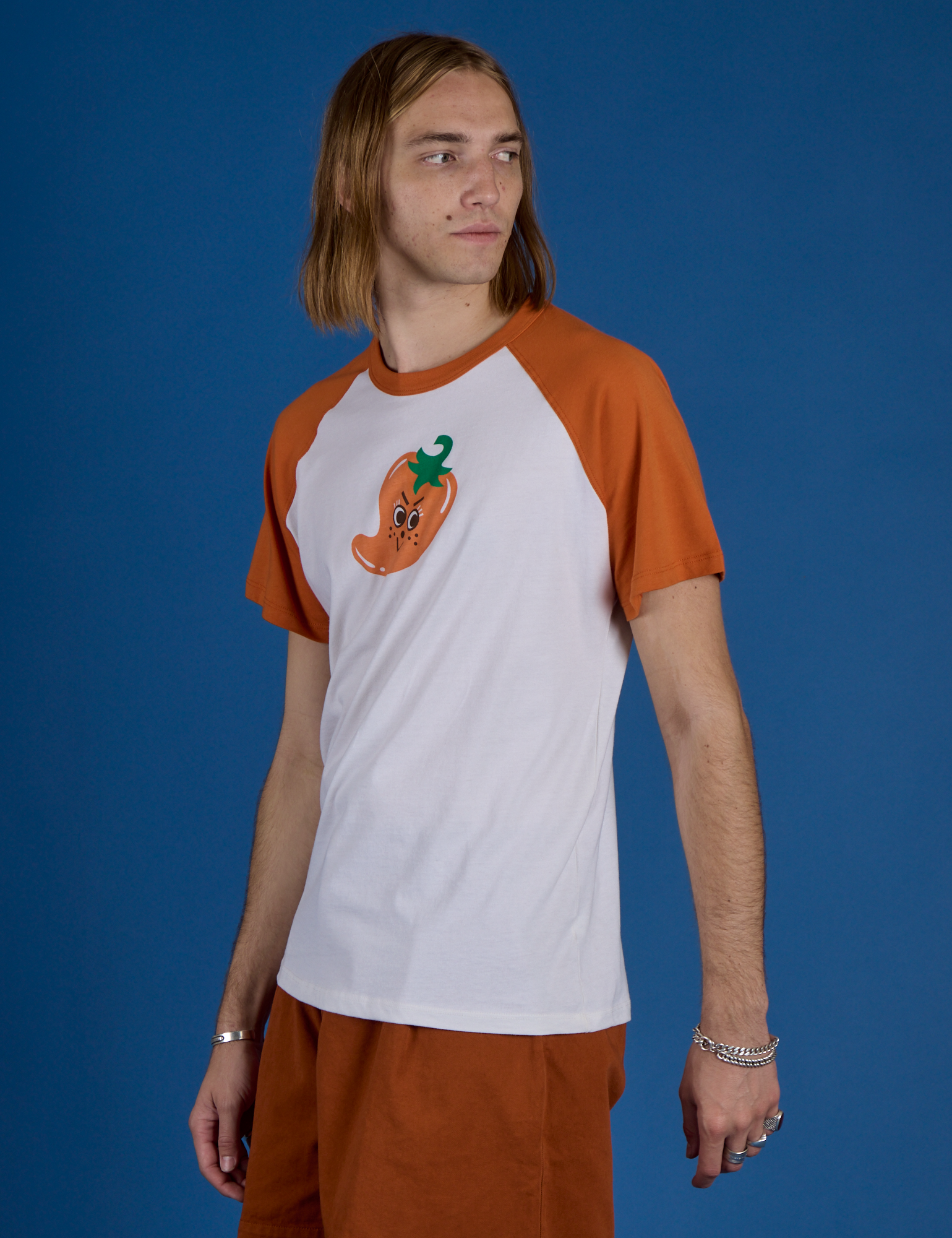 Angled front view of Produce Raglan Tee in Habanero on Grant