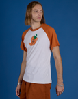 Angled front view of Produce Raglan Tee in Habanero on Grant