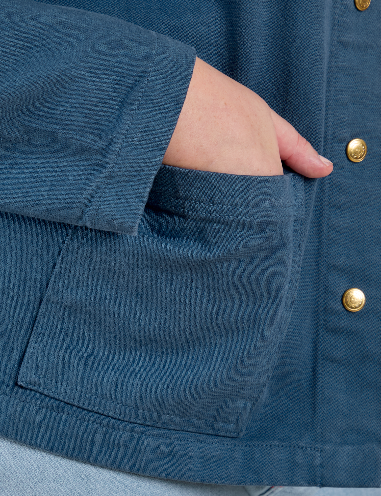 Close up of Juliet's hand in the front pocket of Denim Work Jacket in French Blue