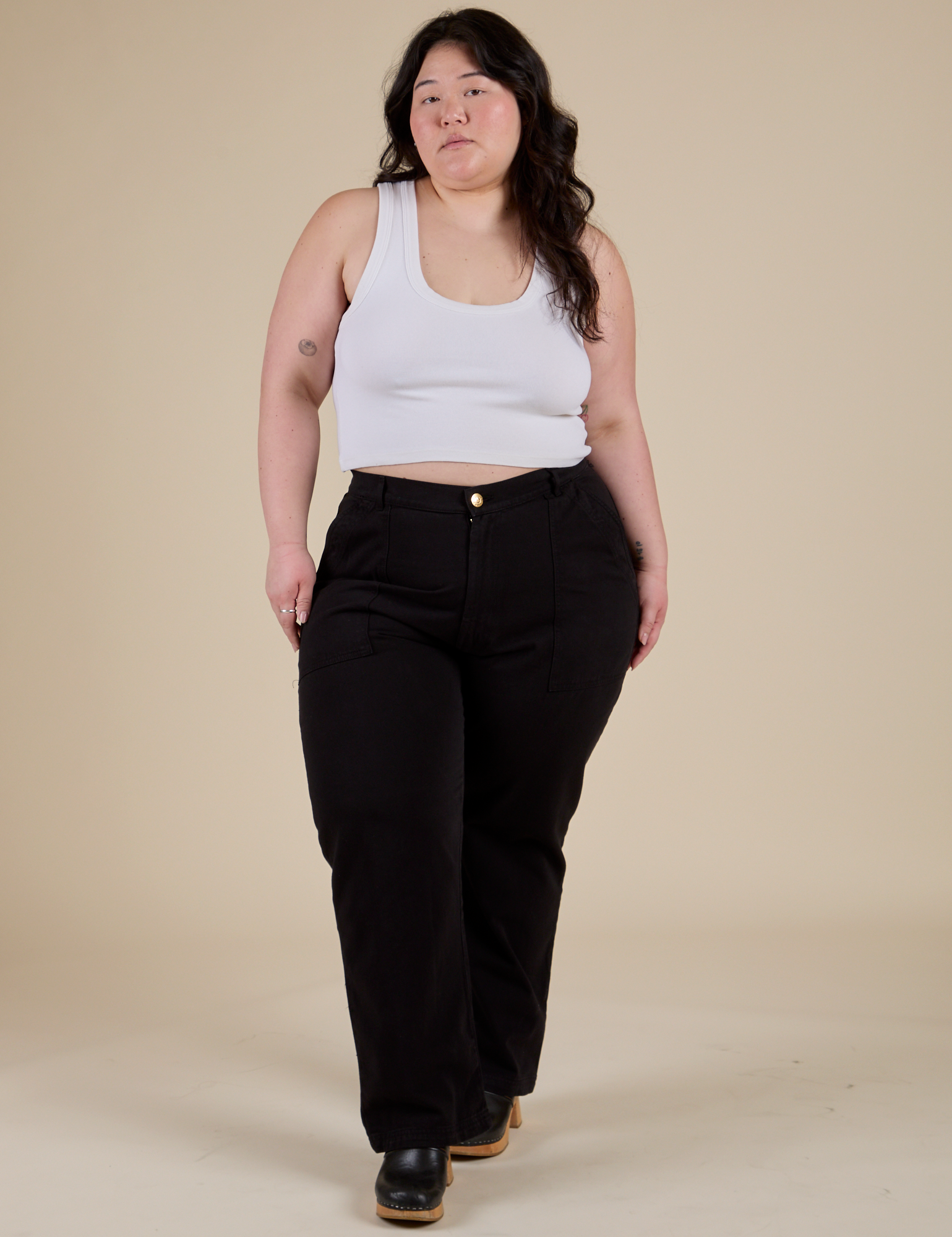 Ashley is wearing Work Pants in Basic Black and vintage tee white Cropped Tank