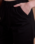 Close up of Alex's hand in the front pocket of Action Pants in Basic Black