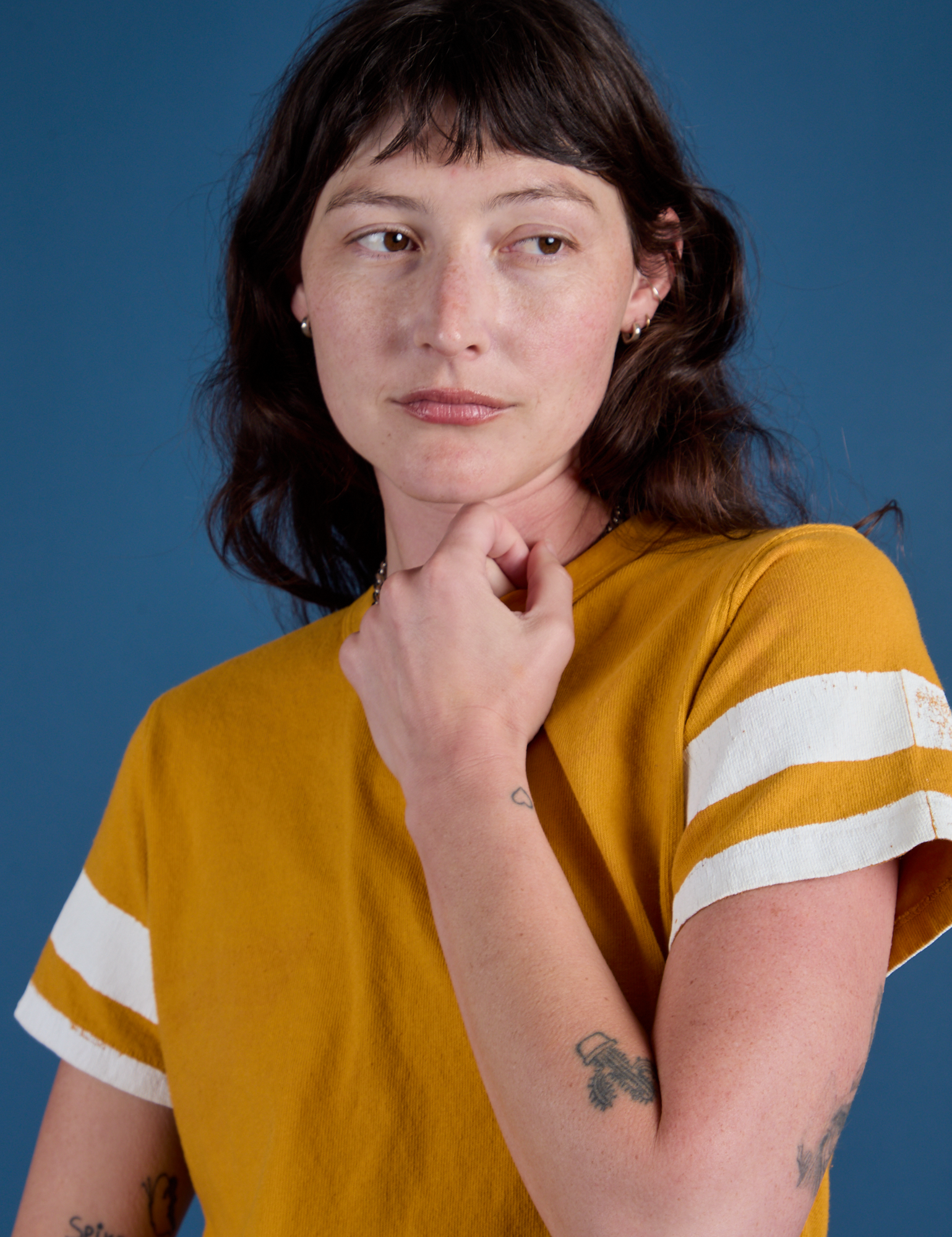 Front close up of Painted Burly Tee in Mustard Yellow on Alex