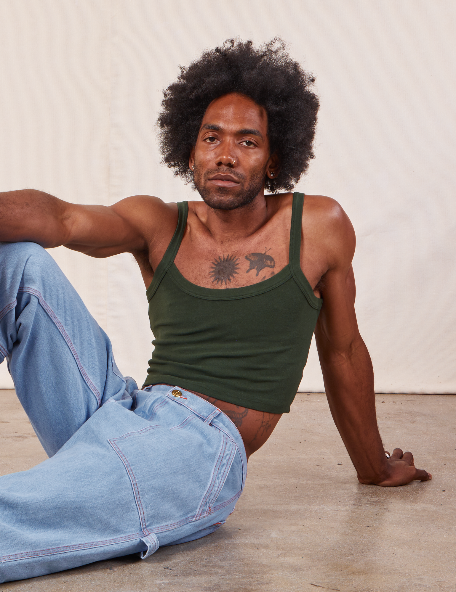 Jerrod is wearing Cropped Cami in Swamp Green and light wash Carpenter Jeans