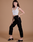 Side view of Carpenter Jeans in Black and Cropped Tank in Vintage Tee White on Alex