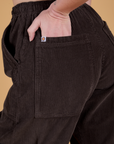 Close up of Alex's hand in the back pocket of Corduroy Drop Pocket Cargo Pants in Espresso Brown