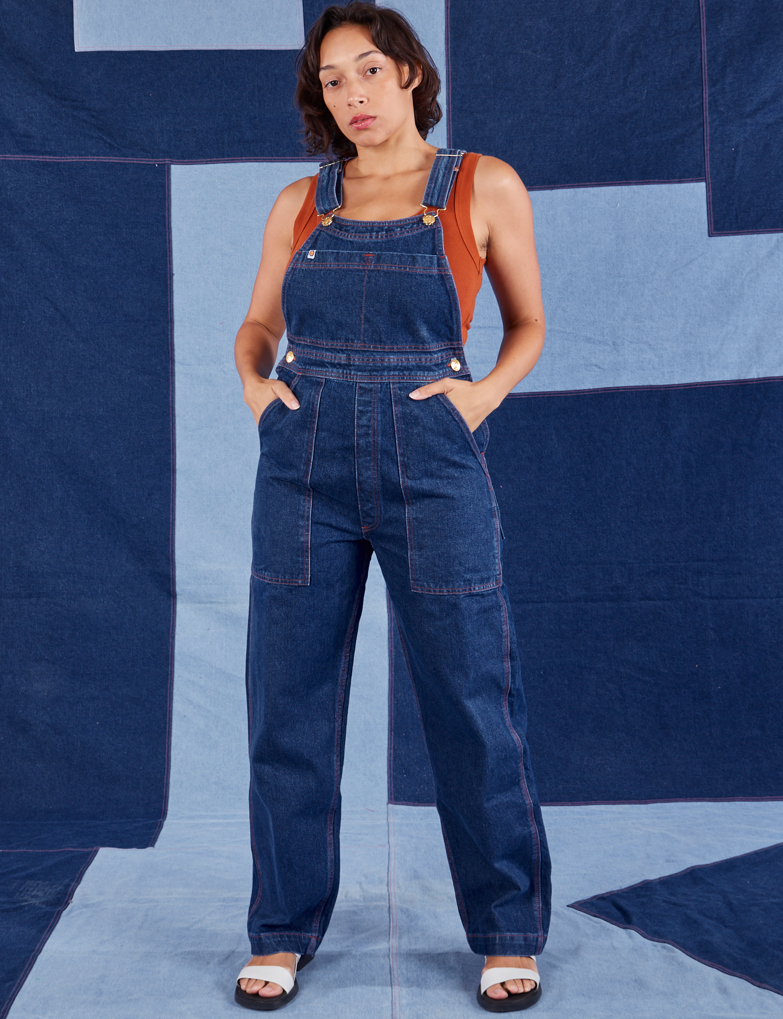 Tiara is 5'4" and wearing XS Indigo Denim Original Overalls in Dark Wash