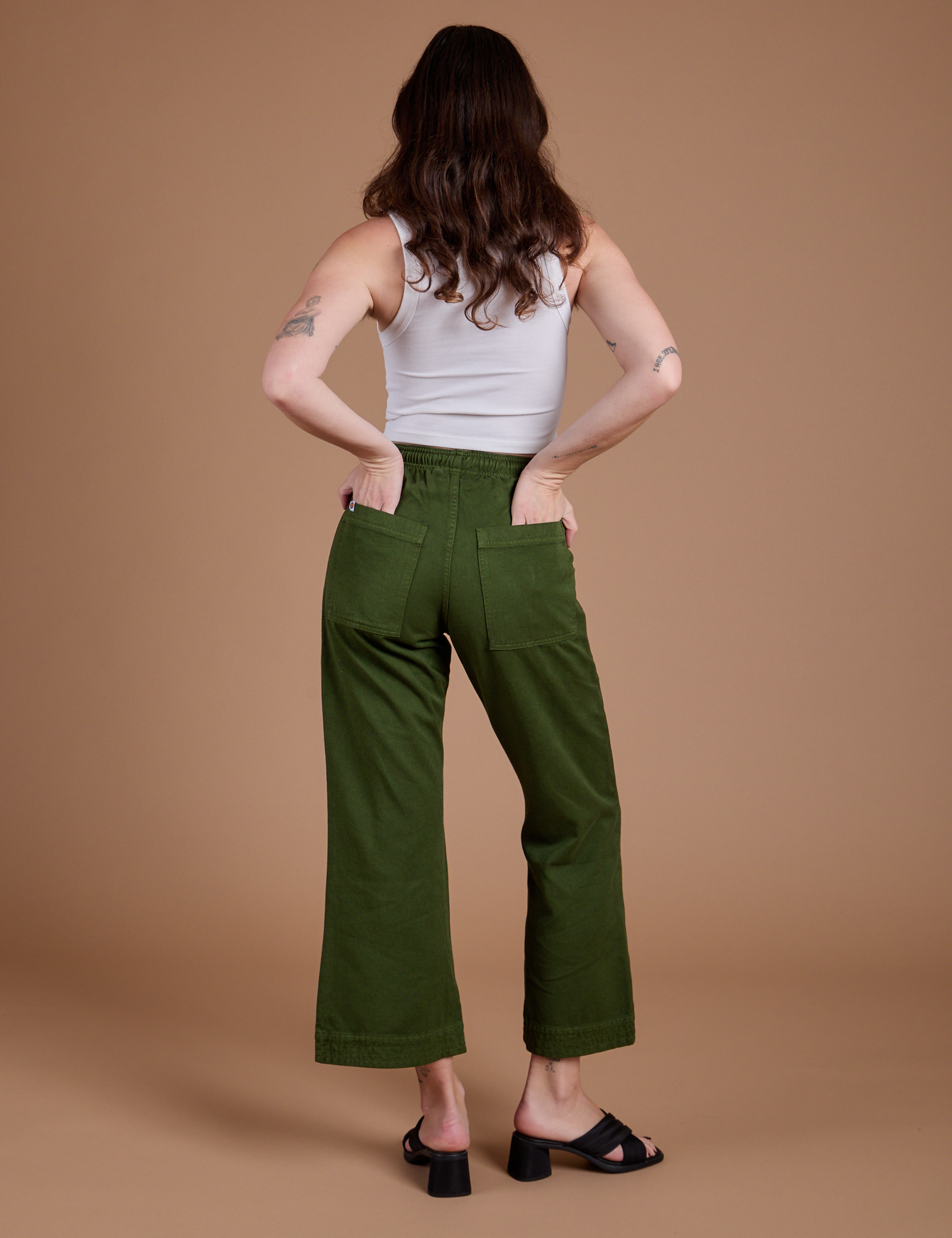 Back view of Organic Action Pants in Evergreen and vintage tee white Cropped Tank