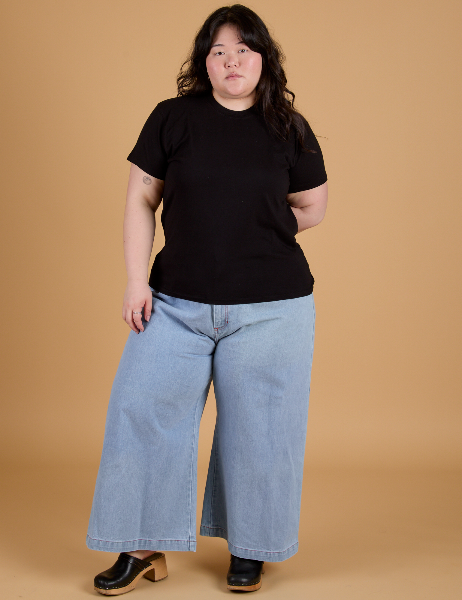 Ashley is wearing Organic Vintage Tee in Basic Black and light wash Indigo Wide Leg Trousers