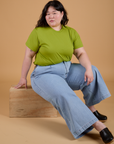 Ashley is wearing Organic Vintage Tee in Gross Green and light wash Indigo Wide Leg Trousers