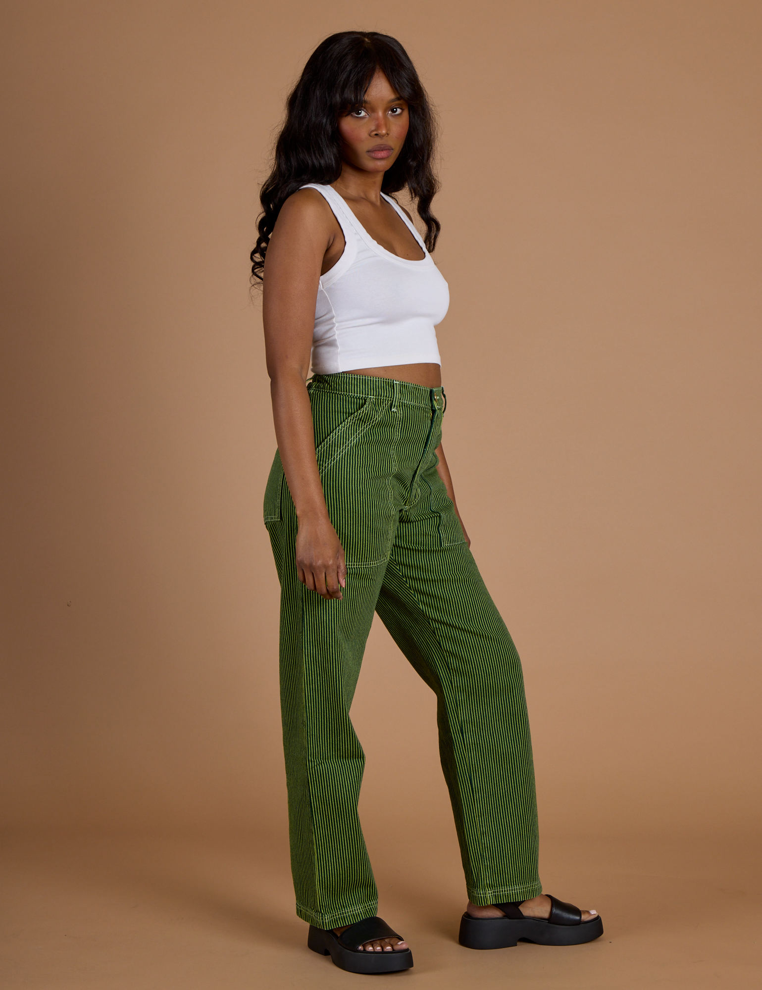 Side view of Railroad Denim Work Pants in Gross Green Overdye and vintage tee white Cropped Tank on Kandia