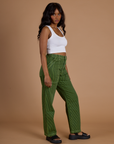 Side view of Railroad Denim Work Pants in Gross Green Overdye and vintage tee white Cropped Tank on Kandia