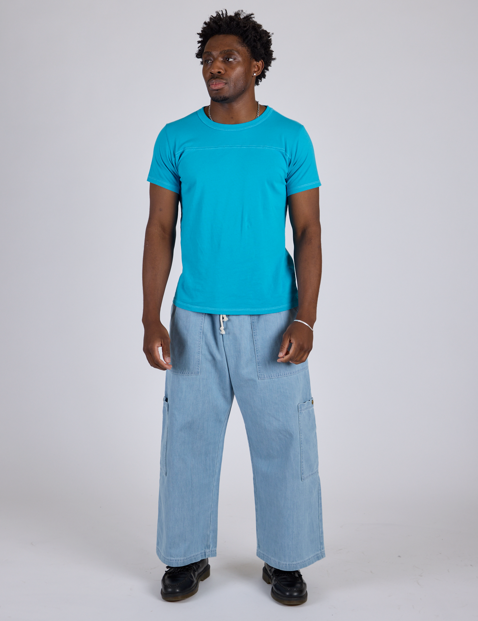 Isaac is wearing Jr. Varsity Tee in Hawaiian Blue and light wash Denim Drop Pocket Pants