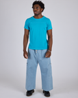 Isaac is wearing Jr. Varsity Tee in Hawaiian Blue and light wash Denim Drop Pocket Pants