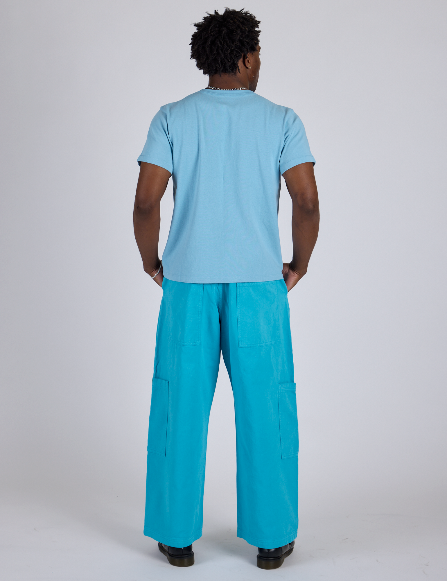 Back view of Drop Pocket Cargo Pants in Hawaiian Blue and baby blue Organic Vintage Tee on Isaac