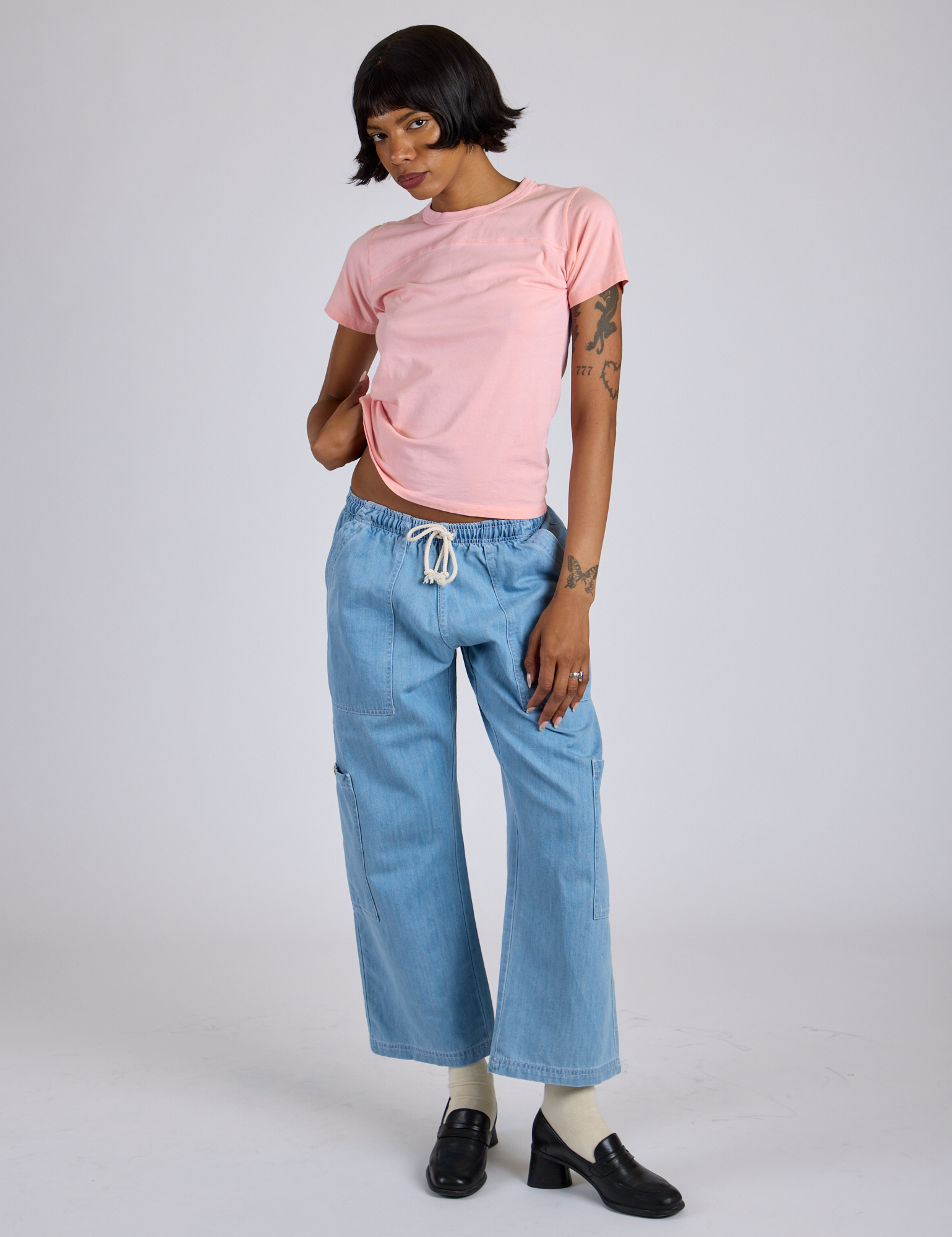 Kira is wearing Jr. Varsity Tee in Baby Pink and light wash Denim Drop Pocket Pants