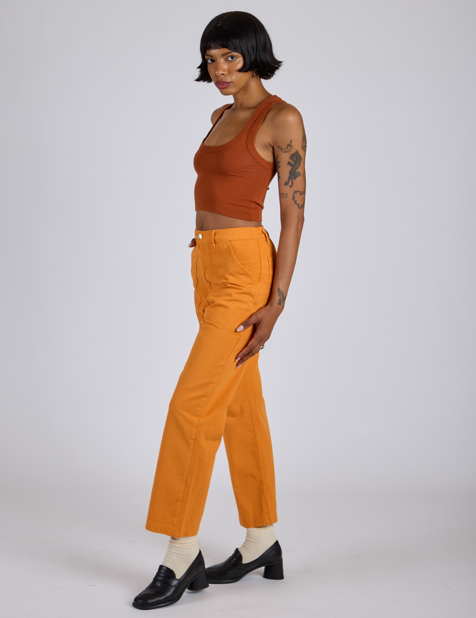 Side view of Work Pants in Creamsicle Orange and burnt terracotta Cropped Tank on Kira
