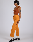 Side view of Work Pants in Creamsicle Orange and burnt terracotta Cropped Tank on Kira