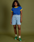 Kandia is 5’3” and wearing P Vintage Ringer Tee in Royal Blue paired with light wash Carpenter Shorts