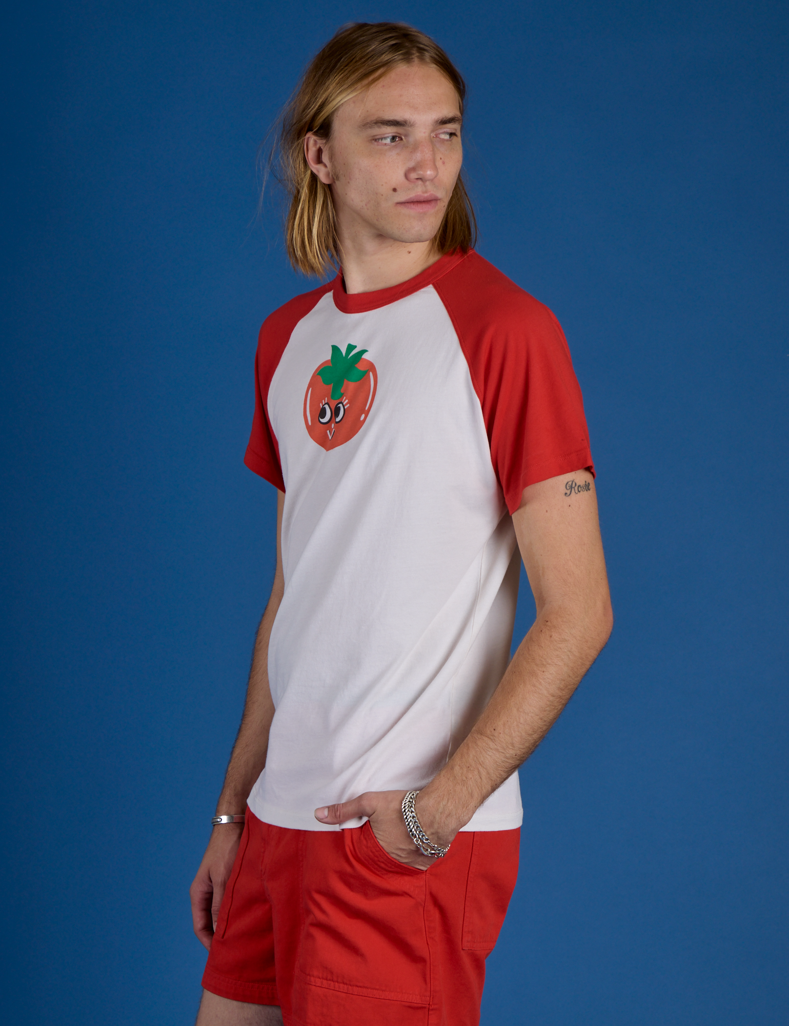 Angled front view of Produce Raglan Tee in Tomato on Grant