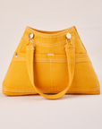 Overall Handbag in Mustard Yellow with handle strap down