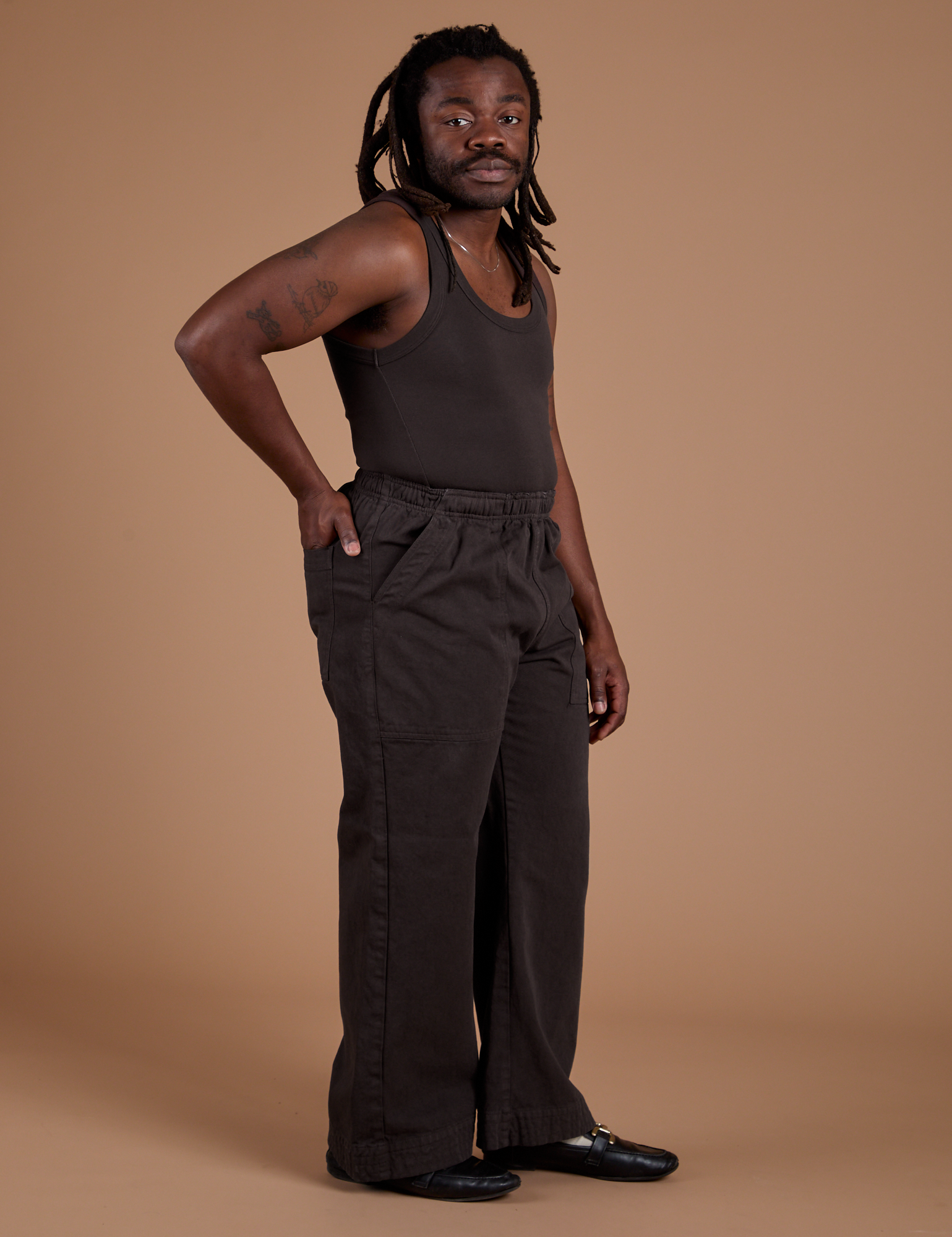 Angled front view of Work Pants in Espresso Brown and matching Tank Top on Demi