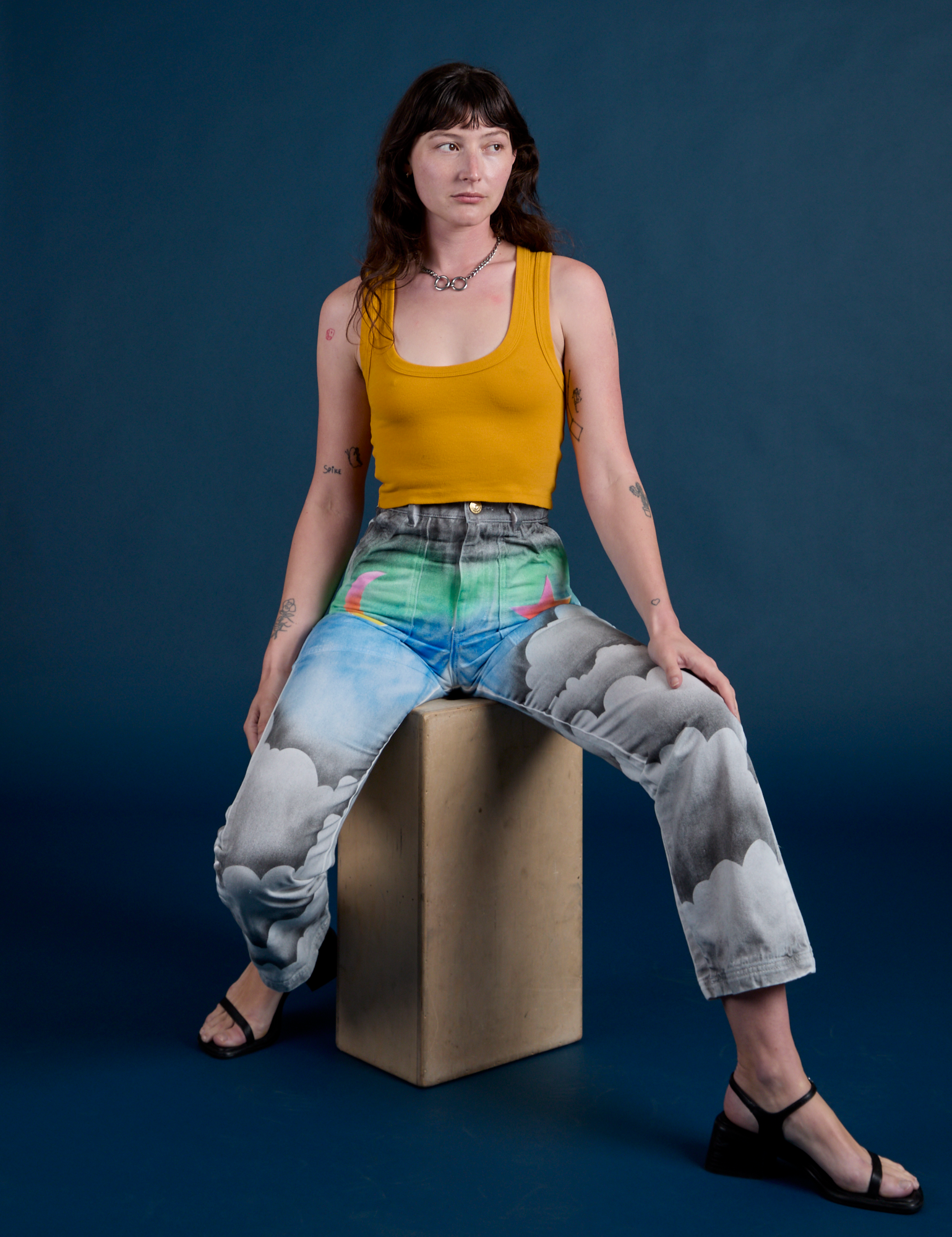 Alex is wearing Work Pants in Night Sky Airbrush and mustard yellow Tank Top